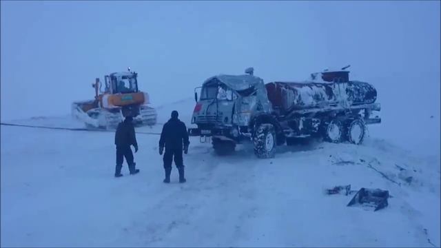 Камаз перевернулся, два бульдозера поднимают.