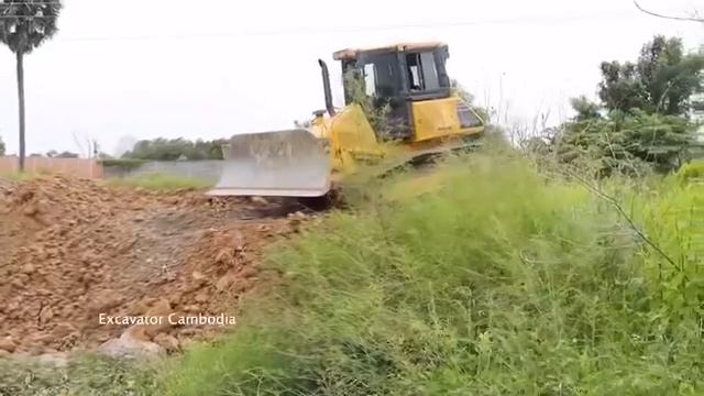 самосвал откатывает застрявшую влажную почву с помощью тяжелого бульдозера skill shantui, изготовле