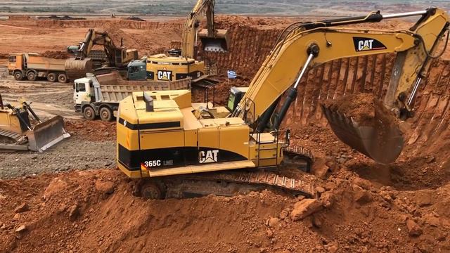 Caterpillar 365C загружает грузовики
